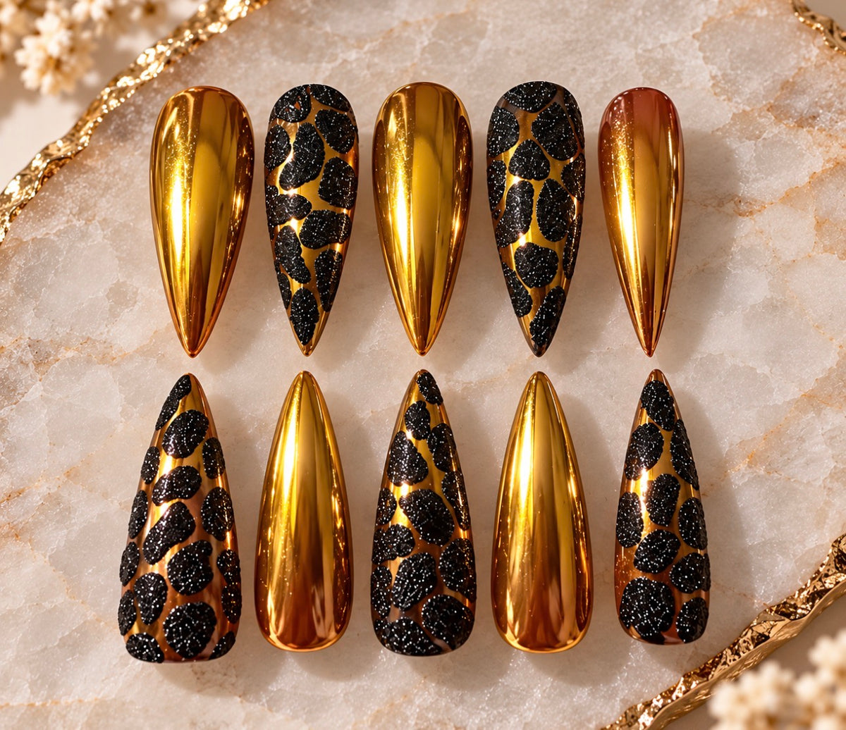 Golden Goddess handmade press-on nails with reflective gold chrome and black textured statement pattern