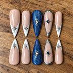 Under the Stars handmade press-on nails with nude, white French tips, blue glitter, silver chrome and starburst crystal accents